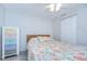 Bedroom features a floral-patterned bedspread, ceiling fan, and a colorful chest of drawers at 2818 Cedaridge Dr, Tampa, FL 33618