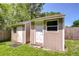 A backyard shed with two separate doors is shown with grass surrounding it at 2818 Cedaridge Dr, Tampa, FL 33618