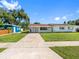 A single-story home with a well-kept lawn and mature trees, showcasing a peaceful residential setting at 302 Patty Dr, Oldsmar, FL 34677