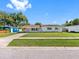 Single-story home featuring a well-manicured lawn and classic architecture in a suburban setting at 302 Patty Dr, Oldsmar, FL 34677