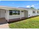 Charming front porch with brick accents, white columns, and a well-maintained lawn and garden at 302 Patty Dr, Oldsmar, FL 34677