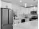 Modern kitchen featuring stainless steel appliances, white cabinets, and quartz countertops at 302 Patty Dr, Oldsmar, FL 34677