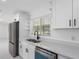 Kitchen with stainless appliances and white cabinets offers sleek lines and modern finishes at 302 Patty Dr, Oldsmar, FL 34677