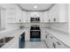 Modern kitchen features white cabinets, stainless steel appliances, and updated countertops at 302 Patty Dr, Oldsmar, FL 34677