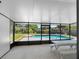Enclosed patio featuring pool view, picnic table, and screened windows at 302 Patty Dr, Oldsmar, FL 34677
