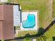 Aerial view of backyard pool with blue water, concrete deck, and green grass at 302 Patty Dr, Oldsmar, FL 34677