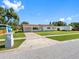 Exterior view of a single-story home featuring a spacious yard, driveway, and well-maintained street at 302 Patty Dr, Oldsmar, FL 34677