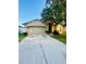 Beige two-story home with a two-car garage and a concrete driveway at 30742 Birdhouse Dr, Wesley Chapel, FL 33545