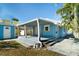 Exterior view of a blue home featuring a covered back porch and palm trees at 3108 Dupont S St, Gulfport, FL 33707