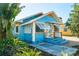 Attractive exterior shot showcasing the bright blue of this home, with tropical landscaping at 3108 Dupont S St, Gulfport, FL 33707