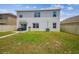 Back exterior view of a two-story home with a fenced yard, patio seating, and grassy lawn at 33524 Elm Hill Br, Wesley Chapel, FL 33545