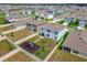 Aerial view of a large backyard featuring a playset, raised garden beds and a white picket fence at 33524 Elm Hill Br, Wesley Chapel, FL 33545