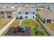Aerial view of a spacious backyard with a playset, garden and patio seating area, surrounded by a fence at 33524 Elm Hill Br, Wesley Chapel, FL 33545