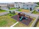 Aerial view of a backyard featuring a playset and gardening beds in a well-manicured and fenced lawn at 33524 Elm Hill Br, Wesley Chapel, FL 33545