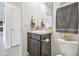 Compact half bath with a modern vanity, decorative towels and flowers, and a toilet at 33524 Elm Hill Br, Wesley Chapel, FL 33545