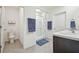 Bathroom featuring a glass-enclosed shower, dual sinks, and stylish blue accents at 33524 Elm Hill Br, Wesley Chapel, FL 33545