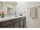 Bathroom with double sink vanity, decorative flower accents, and ample counter space at 33524 Elm Hill Br, Wesley Chapel, FL 33545