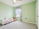 Comfortable bedroom with plush carpet, ceiling fan and a window with decorative curtains allowing natural light at 33524 Elm Hill Br, Wesley Chapel, FL 33545