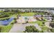 Aerial view of community pool, splash pad, basketball court, and pond with lush landscaping and plenty of space at 33524 Elm Hill Br, Wesley Chapel, FL 33545