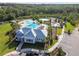 Aerial view of a community center showcasing a pool, splash pad, and playground surrounded by parking at 33524 Elm Hill Br, Wesley Chapel, FL 33545