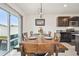 Dining room adjacent to kitchen featuring hardwood table, chairs, and sliding doors at 33524 Elm Hill Br, Wesley Chapel, FL 33545