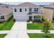 Charming two-story home featuring a manicured lawn and attached two-car garage at 33524 Elm Hill Br, Wesley Chapel, FL 33545