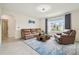 Comfortable living room featuring a leather couch, chair, accent rug, and natural lighting at 33524 Elm Hill Br, Wesley Chapel, FL 33545