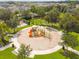 Aerial view of a playground featuring colorful play structures, surrounded by lush landscaping at 33524 Elm Hill Br, Wesley Chapel, FL 33545