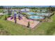 Aerial photo captures a playground, splash pad, and pool in a residential community with lush landscaping at 33524 Elm Hill Br, Wesley Chapel, FL 33545