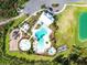 Overhead shot of a pool and splash pad with lounge chairs, landscaping and a nearby playground at 33524 Elm Hill Br, Wesley Chapel, FL 33545