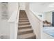 Carpeted staircase with white railings leading to an upstairs living area with a brown couch at 33524 Elm Hill Br, Wesley Chapel, FL 33545