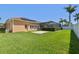 A manicured backyard features lush green grass, solar panels, and a screened-in lanai by the home at 3737 Gaviota Dr, Sun City Center, FL 33573