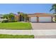 Charming single-story home with a red tile roof, lush landscaping, and a two-car garage at 3737 Gaviota Dr, Sun City Center, FL 33573