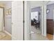 Hallway showing bathroom and office entrances, and neutral walls and floors at 3737 Gaviota Dr, Sun City Center, FL 33573