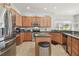 Modern kitchen with stainless steel appliances, center island, granite countertops, and wood cabinets at 3737 Gaviota Dr, Sun City Center, FL 33573