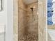 Shower stall featuring stone floor and tiled walls, adjacent to fresh towels at 3737 Gaviota Dr, Sun City Center, FL 33573