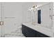 Modern bathroom with navy blue cabinets, white marble countertop, and sleek gold fixtures at 403 E Davis Blvd, Tampa, FL 33606
