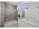 Bathroom featuring modern tile accents, shower-over-tub, sleek vanity, and a large window at 403 E Davis Blvd, Tampa, FL 33606