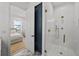 Elegant bathroom featuring a glass shower with gold fixtures, view into bedroom, and stylish geometric floor tiles at 403 E Davis Blvd, Tampa, FL 33606