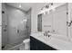 Modern bathroom with a glass-enclosed shower, dark vanity with white countertops, and stylish lighting at 403 E Davis Blvd, Tampa, FL 33606