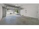 Empty two-car garage with an open garage door, visible concrete floor, and white brick walls at 403 E Davis Blvd, Tampa, FL 33606