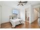 Bright bedroom features hardwood floors, ceiling fan, large window, and ensuite bathroom at 407 S Fremont Ave # B, Tampa, FL 33606