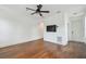 Spacious bedroom with hardwood floors, neutral walls, ceiling fan, arched doorway, and mounted television at 407 S Fremont Ave # B, Tampa, FL 33606