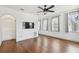 Bedroom featuring hardwood floors, white walls, a ceiling fan, TV, and an arched doorway at 407 S Fremont Ave # B, Tampa, FL 33606