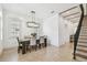Bright dining area with modern chandelier, large windows, and staircase view at 407 S Fremont Ave # B, Tampa, FL 33606