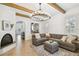 Bright living room featuring exposed beams, modern lighting, and elegant fireplace with views to the kitchen at 407 S Fremont Ave # B, Tampa, FL 33606