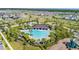 Aerial view showcasing a community pool and clubhouse with surrounding palm trees at 4917 Eagle Rock Dr, Wimauma, FL 33598