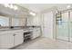 Large primary bathroom featuring double sinks with granite counters, white cabinets, and a glass-enclosed shower at 4917 Eagle Rock Dr, Wimauma, FL 33598
