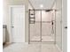 Bathroom showcasing a sleek glass-enclosed shower with modern fixtures, alongside neutral tiling and a convenient shower caddy at 4917 Eagle Rock Dr, Wimauma, FL 33598