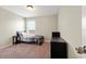 A cozy bedroom featuring carpet, a bed, a nightstand, a dresser, and natural light from a window at 4917 Eagle Rock Dr, Wimauma, FL 33598